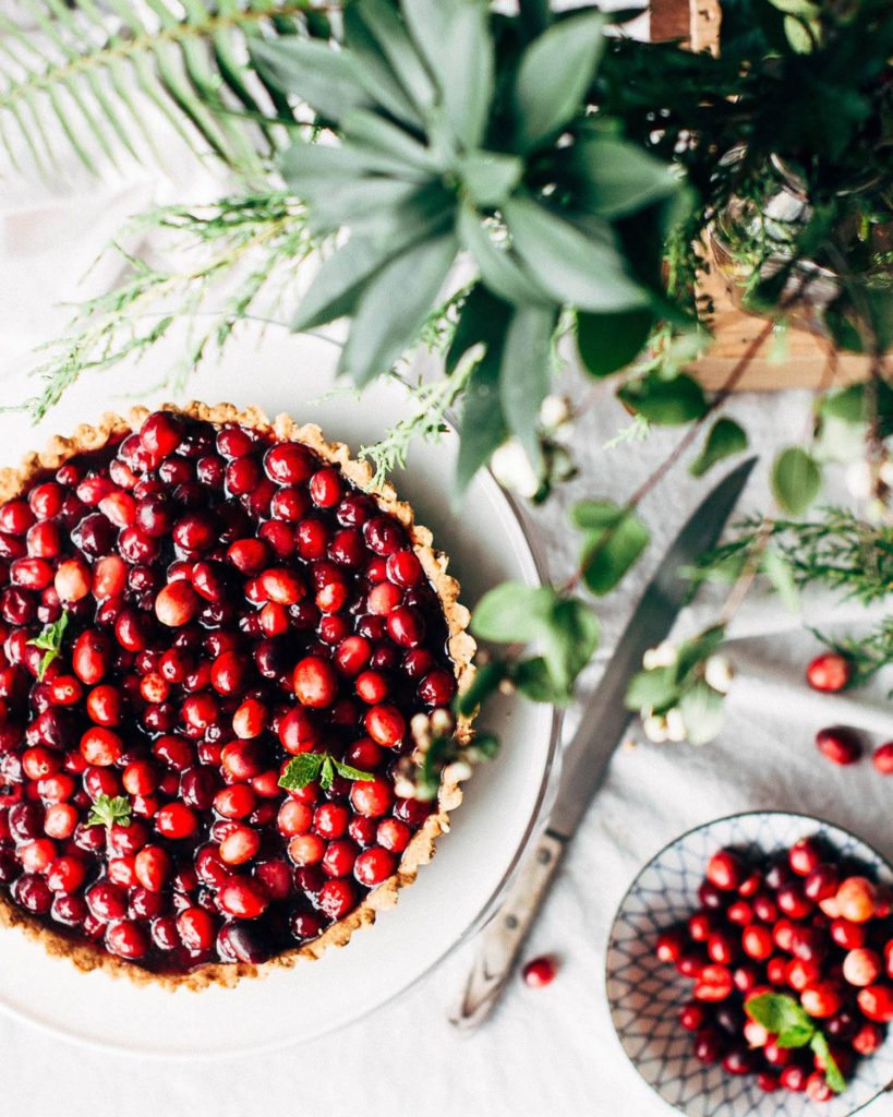 A cranberry tart surrounded by leaves