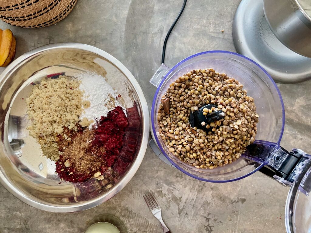 ingredients for lentil burgers shown partially in a bowl and in a food processor