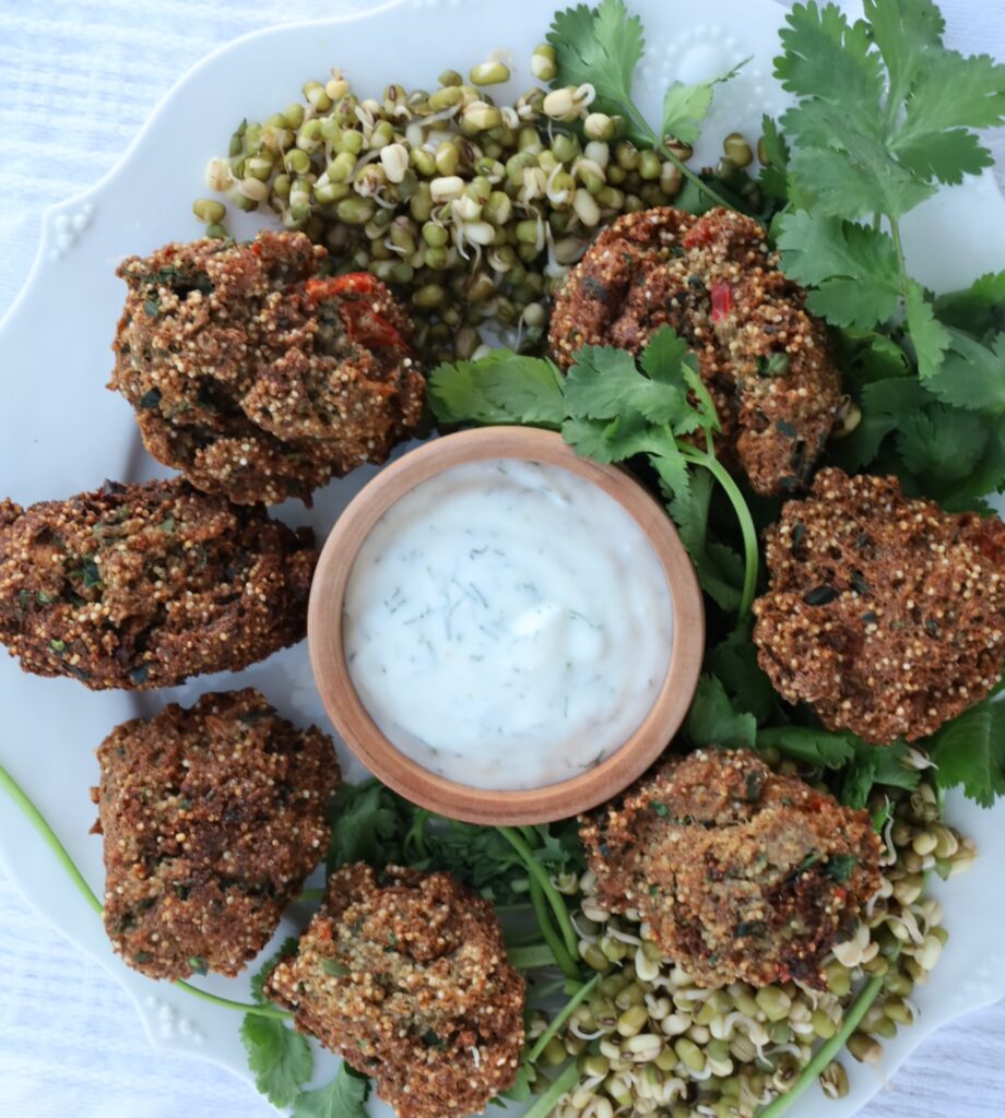 a circle of amaranth puffs surrounds a bowl of dill yogurt....garnished by some mung beans and cilantro.