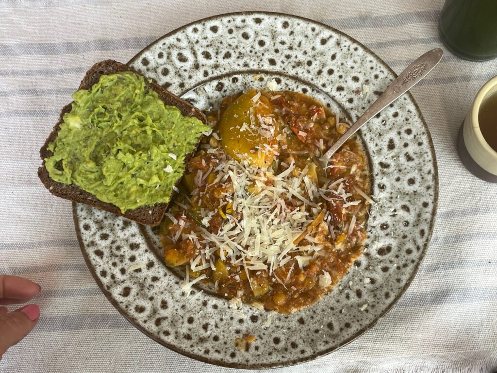 Avocado toast and summer stew in a speckled pottery bowl