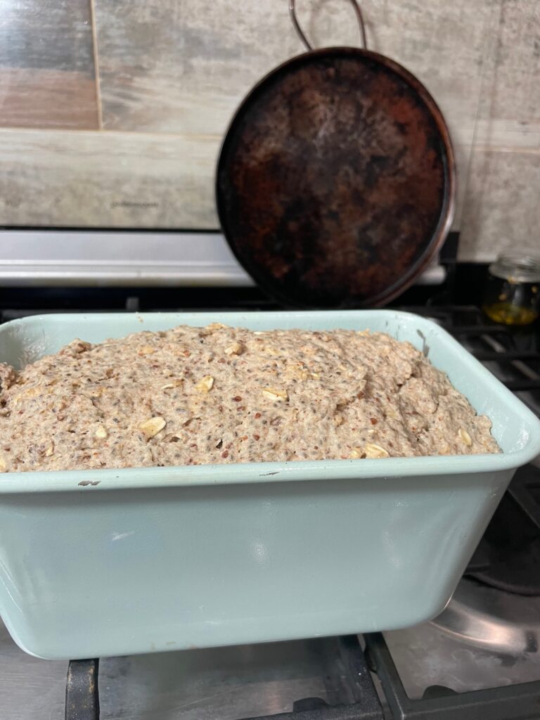 A photo of chia bread dough that has risen to the perfect level above the artisanal baking pan. 