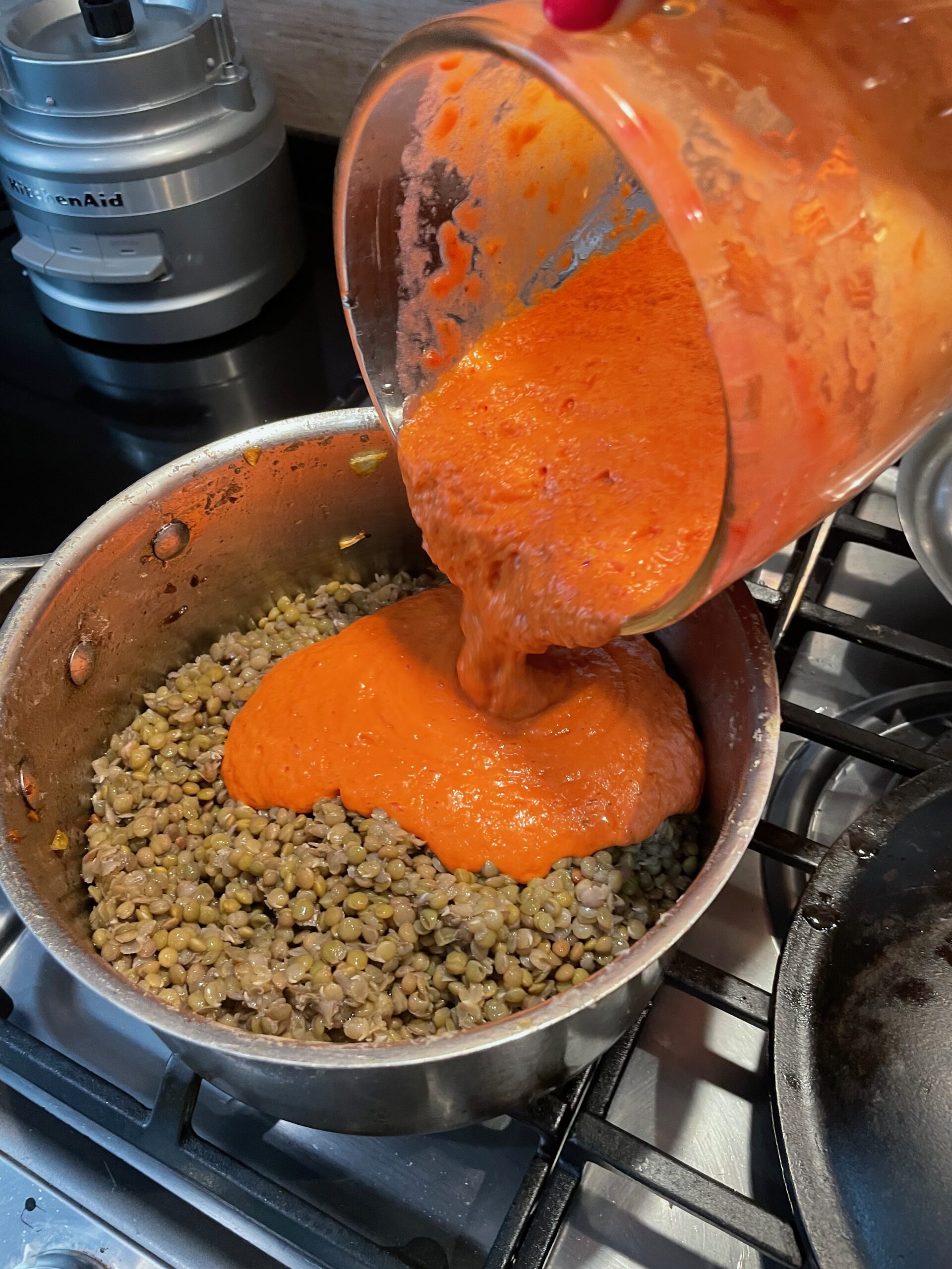 pouring tomato sauce into lentils