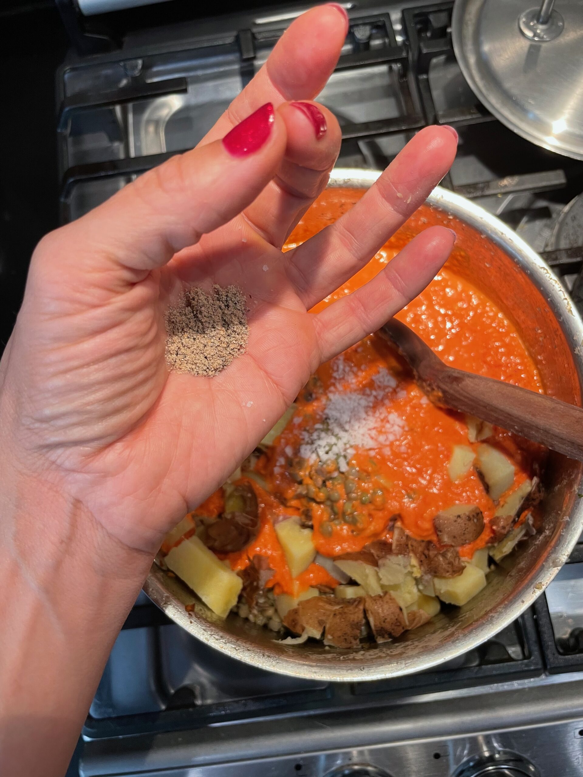 Adding coriander shown in the palm of the hand before being put in pan