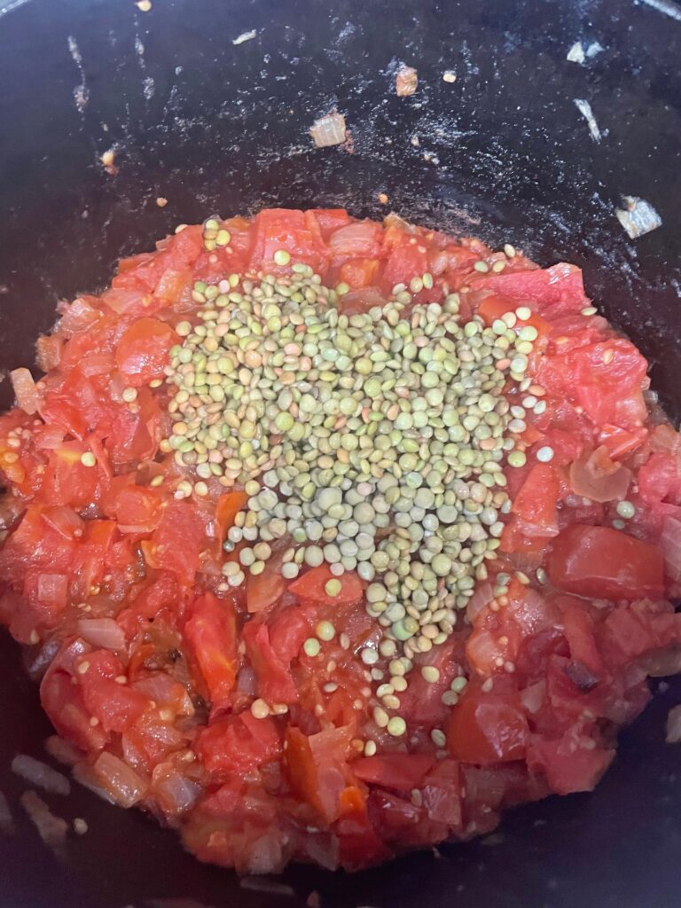 adding the lentils to the pan with the tomatoes