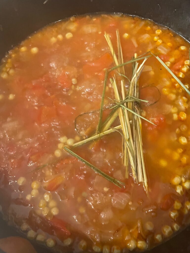 adding the lemongrass to the soup pot