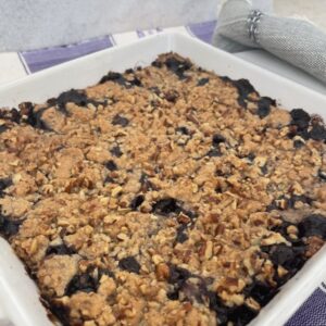 a berry crumble is in a baking white baking mason dish