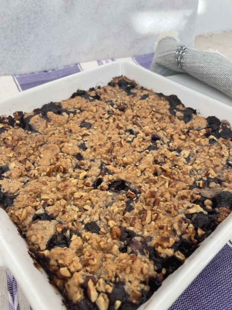 a berry crumble is in a baking white baking mason dish